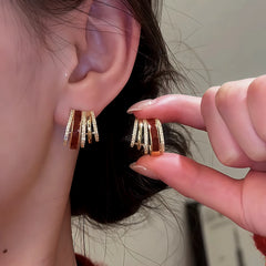 Angled view of the 14K Gold Plated Zircon Drip Glaze Multi-Layer C-Shaped Earrings