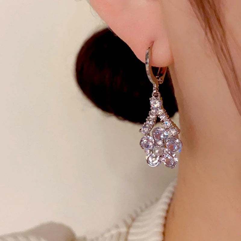 Model showcasing the dangle and style of the 14K Gold Plated Zircon Flower Earrings