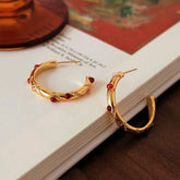 Pair of vintage gold C-hoop earrings with red & pink gems on open book