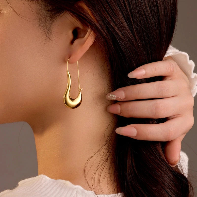 Model showcasing the dangle and style of the 18K Gold-Plated Curved Water Drop Earrings