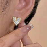Gold pave crystal heart stud earring worn on woman's ear