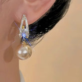 Sparkling gold-tone pave crystal champagne pearl drop earring worn on ear