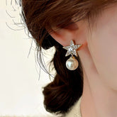 Gold cubic zirconia star pearl drop earring worn on woman's ear side view