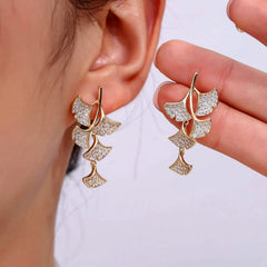 Model showcasing the dangle and style of the 18K Gold-Plated Ginkgo Leaf Earrings
