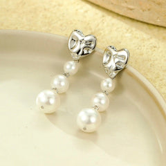 Angled view of the 18K Gold-Plated Heart Pearl Earrings