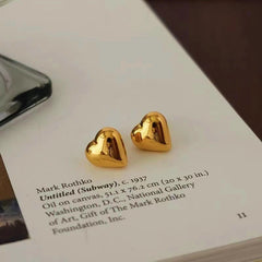 Model showcasing the dangle and style of the 18K Gold-Plated Heart Stud Earrings