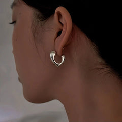 Model showcasing the dangle and style of the 18K Gold-Plated Hollow Heart-Design Earrings