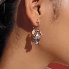 Silver starburst teardrop crystal dangle earring worn on ear
