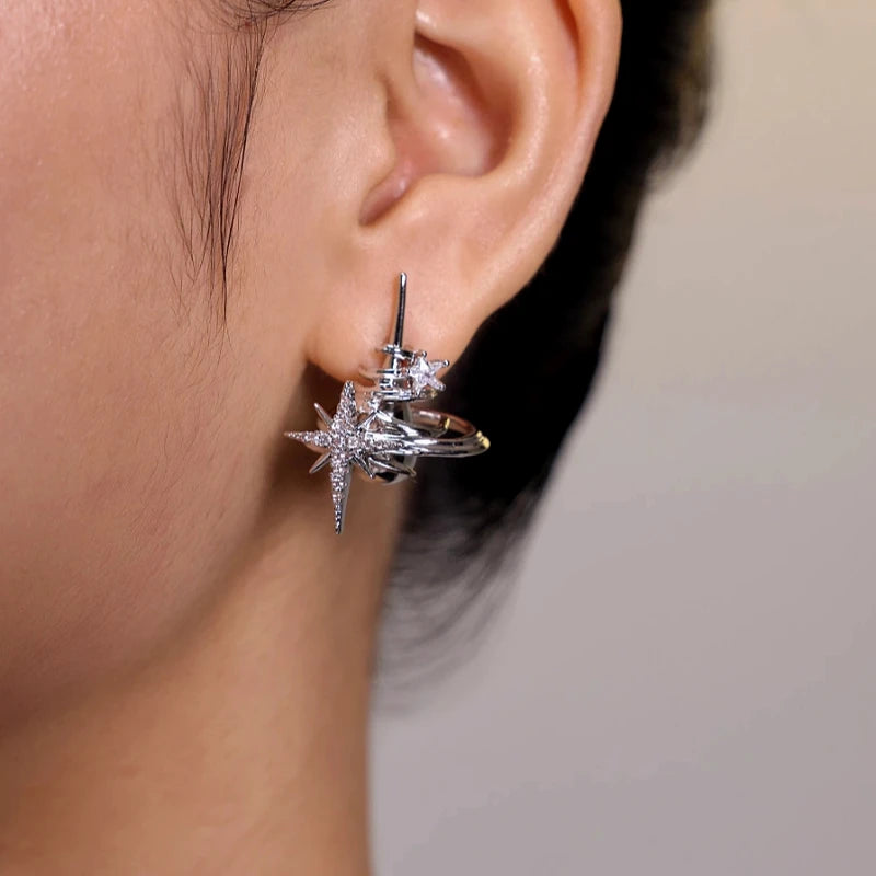 Silver rhinestone starburst Saturn stud earring worn on ear