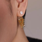 Gold pearl stud drop earring with beaded crystal cluster, worn on ear