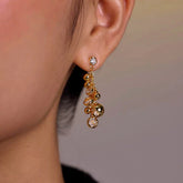 Gold bubble crystal dangle drop earring worn on female earlobe