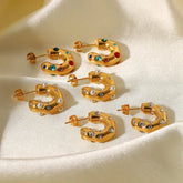 Three pairs of gold chunky C-hoop earrings with colorful gems, pearls, and rhinestones