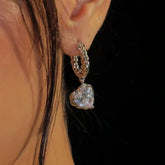 Silver twisted huggie hoop heart cubic zirconia drop earring on ear