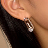 Silver paperclip cubic zirconia stud earring worn on ear close-up