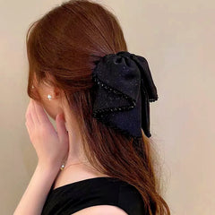 Angled view of the stylish Elegant Starlight Streamer Bow Hair Band