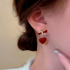 Model showcasing the dangle and style of the Silver Post Bow Heart Earrings