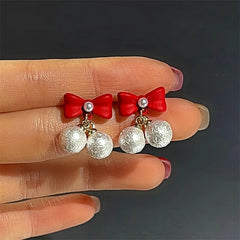Angled view of the Silver Post Christmas Red Bow Bead Earrings
