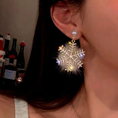 Model showcasing the dangle and style of the Silver Post Christmas Snowflake Pearl Earrings