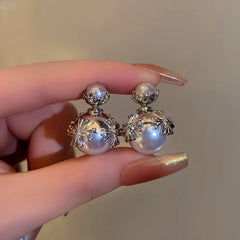 Angled view of the Silver Post Cross Pearl Earrings