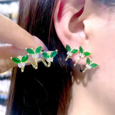 Gold green CZ butterfly ear climber earrings, worn on ear and held in hand