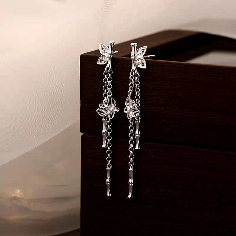 Angled view of the Sterling Silver Bamboo Butterfly Tassel Earrings