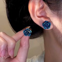 Model showcasing the dangle and style of the Sterling Silver Blue Rose Stud Earrings