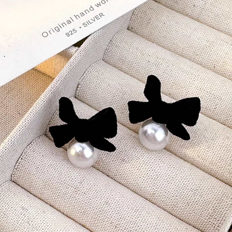 Angled view of the Sterling Silver Bow Pearl Earrings