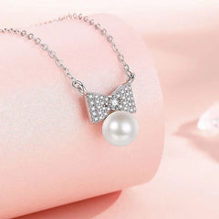 Sterling Silver Bow Pearl Necklaces worn to showcase its length and pendant detail