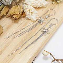 Model showcasing the dangle and style of the Sterling Silver Bow Tassel Threader Earrings