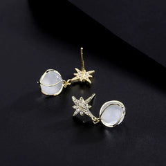 Model showcasing the dangle and style of the Sterling Silver Cat's Eye Stone Zircon Eight-Pointed Star Earrings