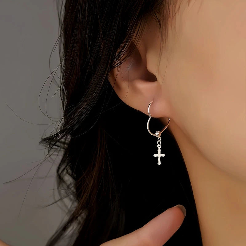 Model showcasing the dangle and style of the Sterling Silver Cross Heart Earrings