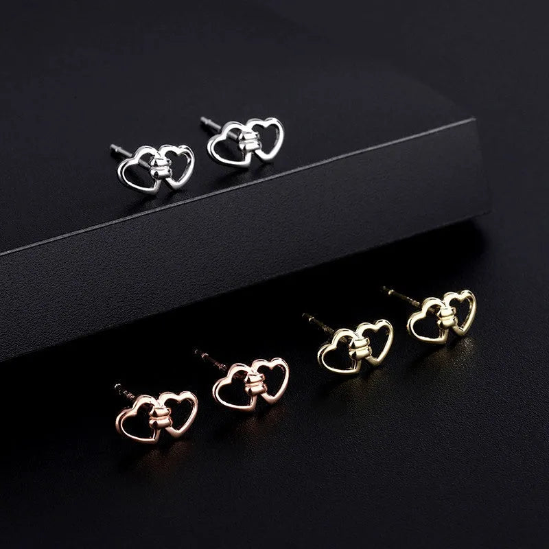 Model showcasing the dangle and style of the Sterling Silver Double Heart Stud Earrings