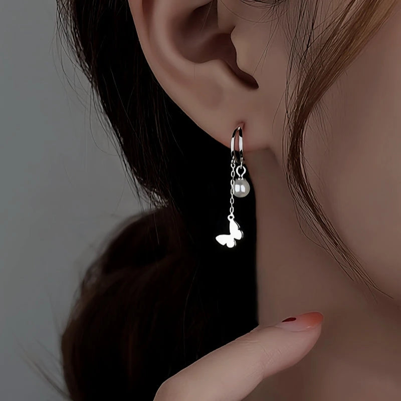 Model showcasing the dangle and style of the Sterling Silver Double Later Butterfly Pearl Earrings