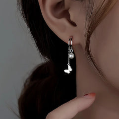 Model showcasing the dangle and style of the Sterling Silver Double Later Butterfly Pearl Earrings