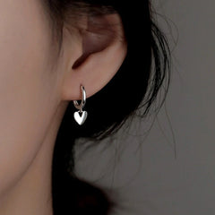 Model showcasing the dangle and style of the Sterling Silver Elegant Heart Earrings