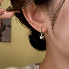 Close-up detail of the sparkling zircons and plating on the silver tassel earrings