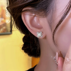 Model showcasing the dangle and style of the 14K Golden-Plated Elegant Zircon Lucky Clover Bead Stud Earrings