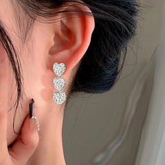 Model showcasing the dangle and style of the Sterling Silver Heart Tassel Earrings