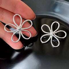Angled view of the Sterling Silver Hollow Flower Knot Earrings