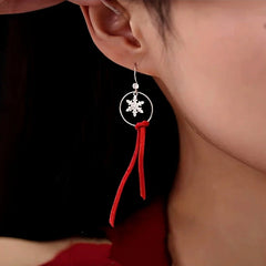 Model showcasing the dangle and style of the Sterling Silver Moose Snowflake Circle Red Velvet Tassel Earrings