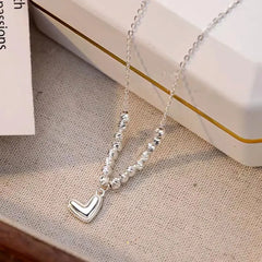 Detailed view of the Sterling Silver Round Bead Heart Necklaces chain and pendant