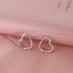 Model showcasing the dangle and style of the Sterling Silver Textured Heart Earrings