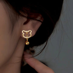 Gold crystal hollow tiger bell dangle stud earring worn on ear