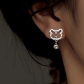 Silver crystal hollow tiger bell dangle stud earring worn on ear