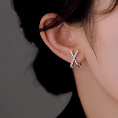 Model showcasing the dangle and style of the Sterling Silver X-Shaped Diamond Stud Earrings
