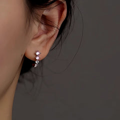 Model showcasing the dangle and style of the Sterling Silver Zircon C-Shaped Earrings