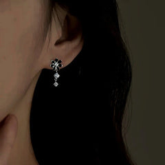 Model showcasing the dangle and style of the Sterling Silver Zircon Daisy Flower Earrings