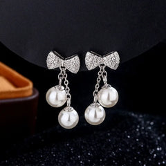 Close-up detail of the sparkling zircons and plating on the Bow Pearl Tassel Earrings