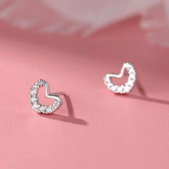 Model showcasing the dangle and style of the Sterling Silver Zircon Diamond Heart Stud Earrings