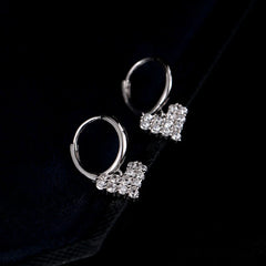 Model showcasing the dangle and style of the Sterling Silver Zircon Heart Earrings